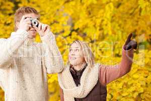 Autumn couple take photo camera in park