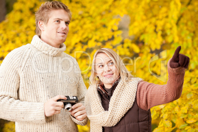 Autumn couple take photo camera in park