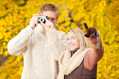 Autumn couple take photo camera in park