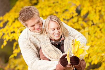 Autumn happy couple holding leaves in  park
