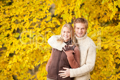 Autumn happy couple hugging together in park