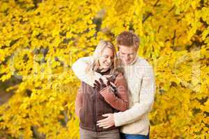 Autumn happy couple hugging together in park