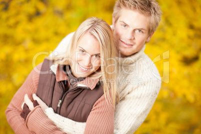 Autumn happy couple hugging together in park