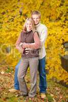 Autumn love couple hugging happy in park
