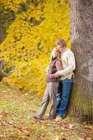 Autumn love couple hugging happy in park