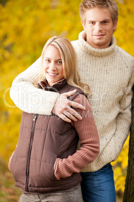 Autumn love couple hugging happy in park