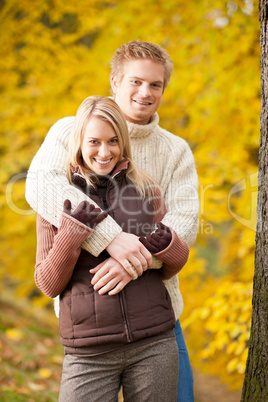 Autumn love couple hugging happy in park