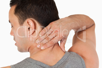 Young male massaging his back