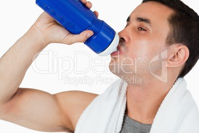 Close up of young male drinking water after workout
