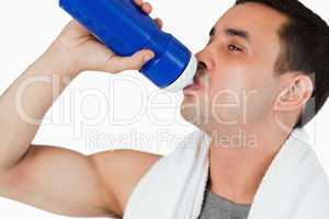 Close up of young male drinking water after workout