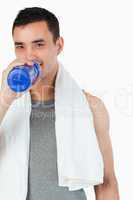 Young man taking a sip of water after training
