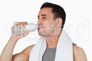 Young male having some water after workout