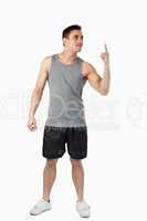 Young man in sports cloths pointing up