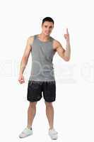 Young male in light sports cloths pointing upwards