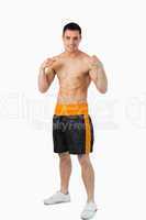 Smiling young boxer with bare fists up