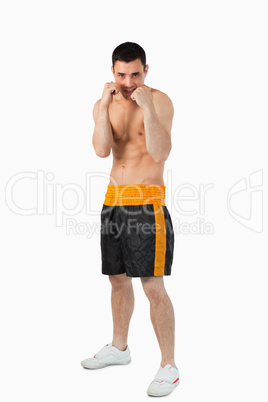 Young boxer with bare fists taking cover