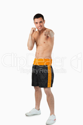 Young smiling boxer striking straight