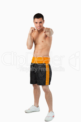 Young boxer with bare fists striking straight