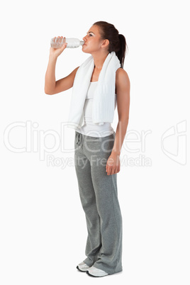 Side view of young female taking a sip of water after training