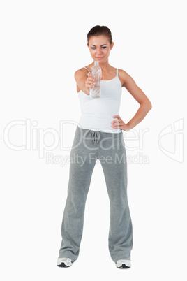 Young female with hand on her hip offering a sip of water