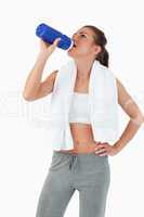 Young female taking a sip out of her bottle after workout