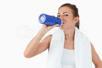 Atletic female taking a sip of water after training