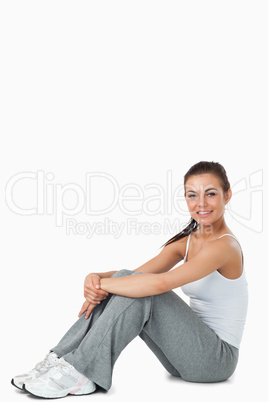Young female in sports wear sitting on the ground