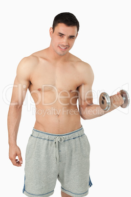 Young male lifting dumbbell