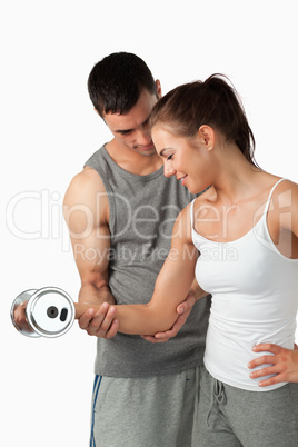 Portrait of a young man helping a woman to work out