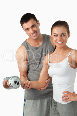 Portrait of a smiling man helping a woman to work out