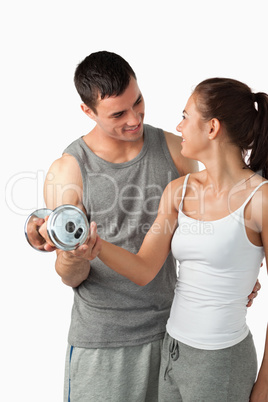 Portrait of a man helping a young woman to work out