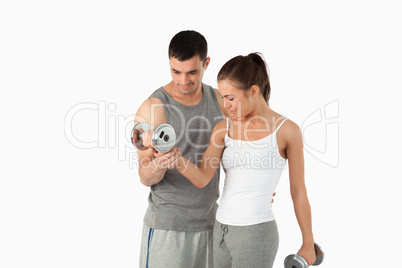 Man helping a woman to work out