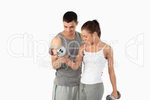 Man helping a woman to work out