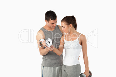 Man helping a young woman to work out