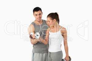 Man helping a cute woman to work out