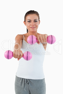 Portrait of a smiling woman working out with dumbbells