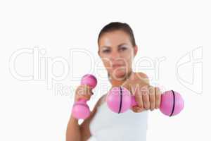 Healthy woman working out with dumbbells