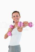 Portrait of a happy woman working out with dumbbells
