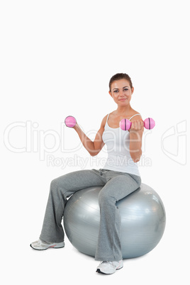 Portrait of a fit woman working out with dumbbells and a ball