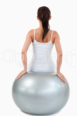 Portrait of a brunette woman working out with a ball