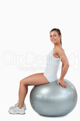 Portrait of a smiling woman working out with a ball