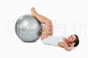Young woman developing her abs with a ball