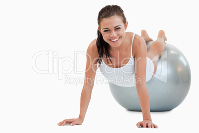 Smiling woman working out with a ball