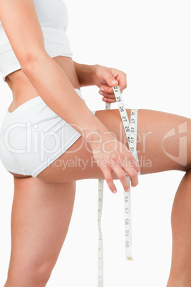 Portrait of a woman measuring her thigh