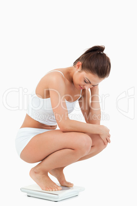 Portrait of a woman squatting on scales