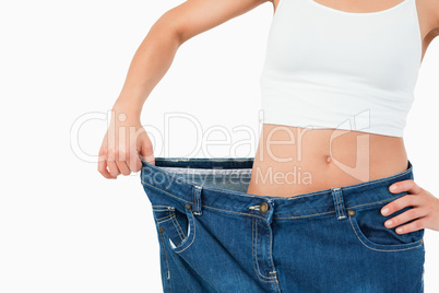Fit woman wearing too large jeans