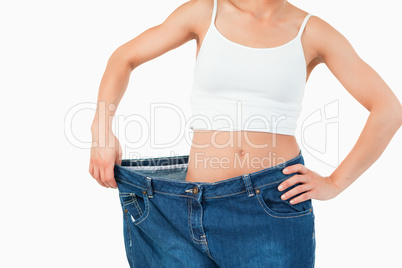 Thin woman wearing too large jeans