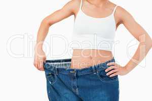 Thin woman wearing too large jeans