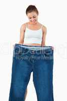 Portrait of a fit woman showing large jeans