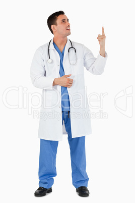 Portrait of a young doctor pointing at a copy space
